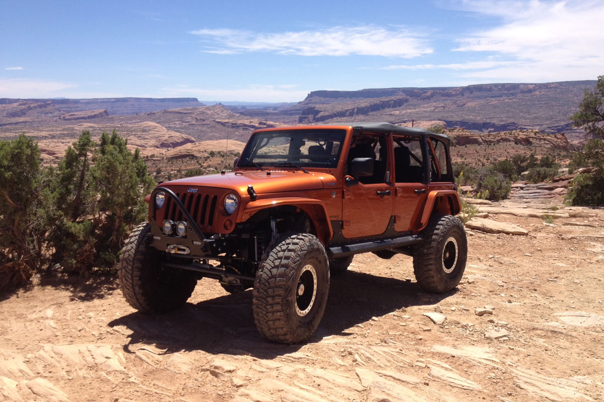 Orange Jeep by a large canyon
