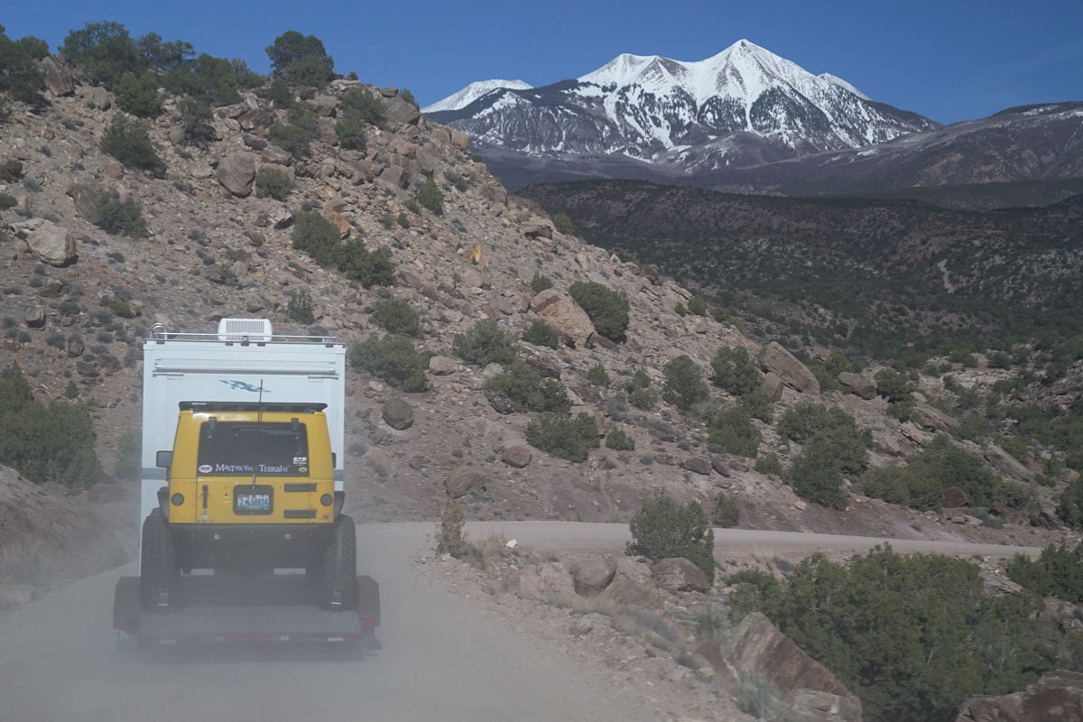 Motor home towing yellow Jeep through the mountains