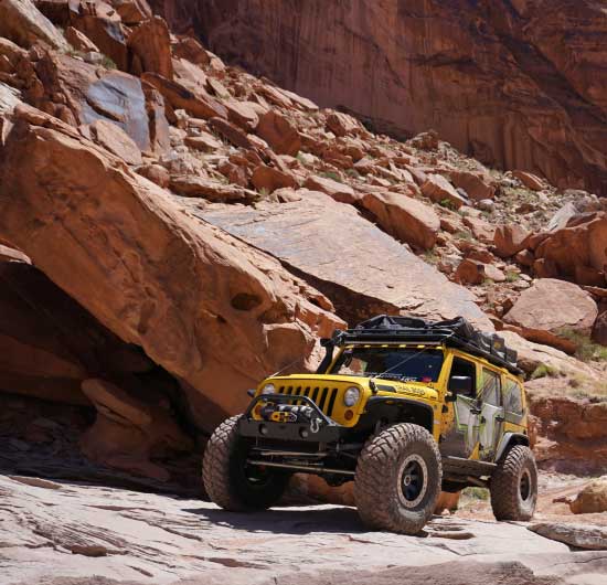Yellow TNT Customs Jeep in front of big rocks - 4Xploring